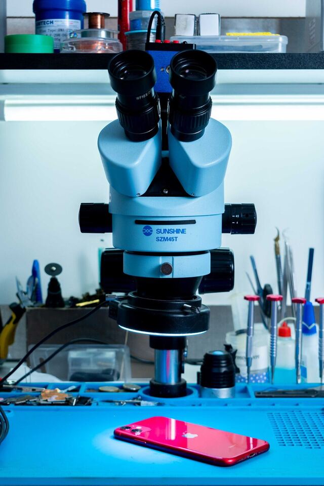 Mikroskop und iPhone am Reparaturplatz — iPhone Reparatur Düsseldorf